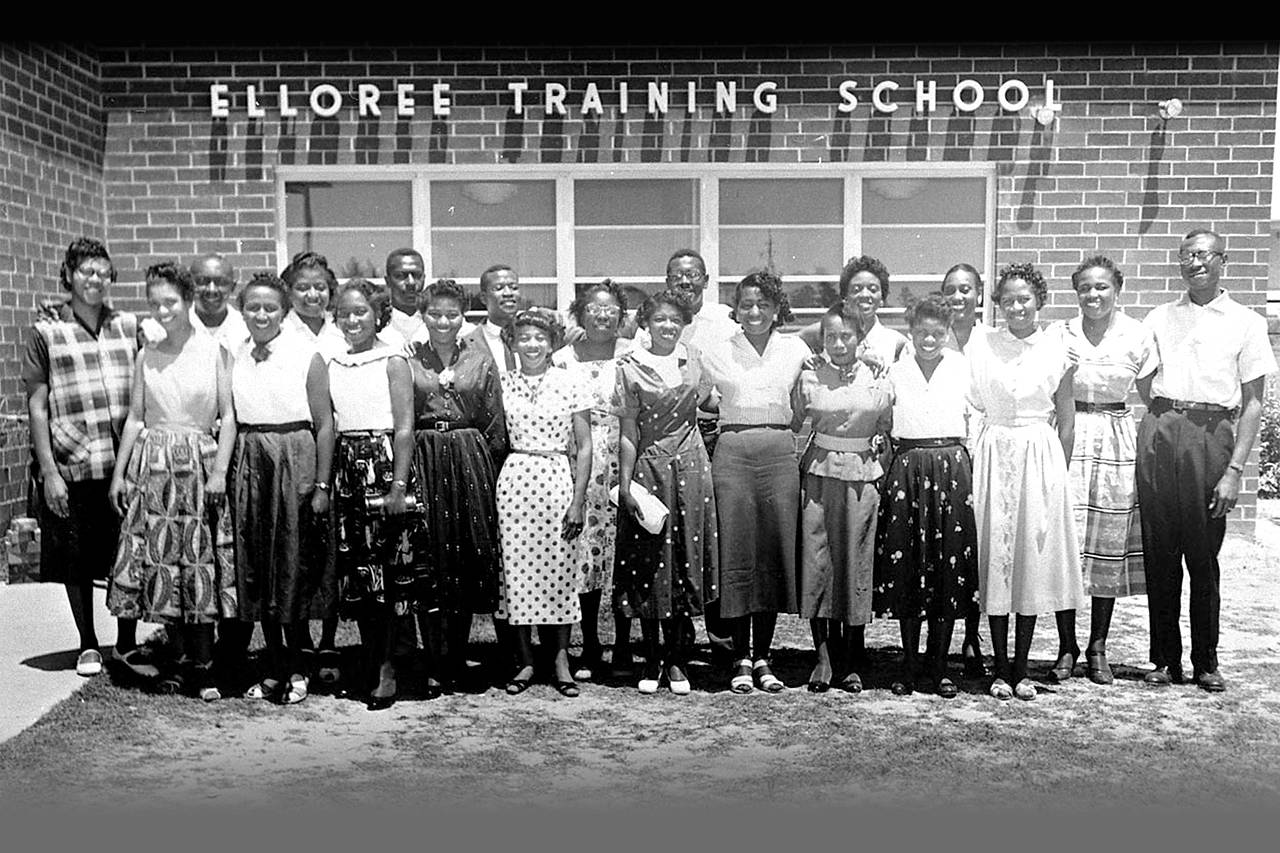 Image: The 21 teachers who lost their positions for their refusal to comply with the anti-NAACP oath standing in front of the  Elloree Training School in Elloree, South Carolina, on May 15, 1956. This photograph appeared in Jet magazine on June 7, 1956.  (Image courtesy of photographer Cecil Williams, Cecil Williams Civil Rights Museum, Orangeburg, South Carolina.)